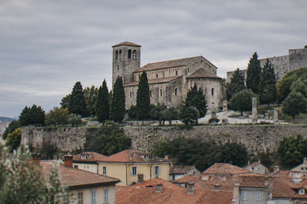 The old town rooftops of Trieste rising below the cathedral and castle on San Giusto hill
