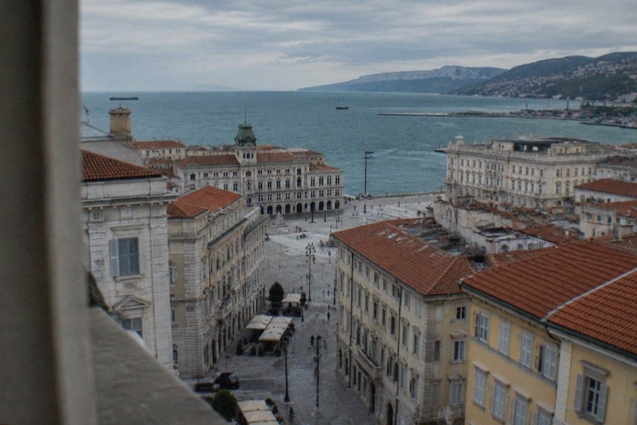 Aerial view over the rooftops of Trieste with the seafront square and the Adriatic Gulf beyond