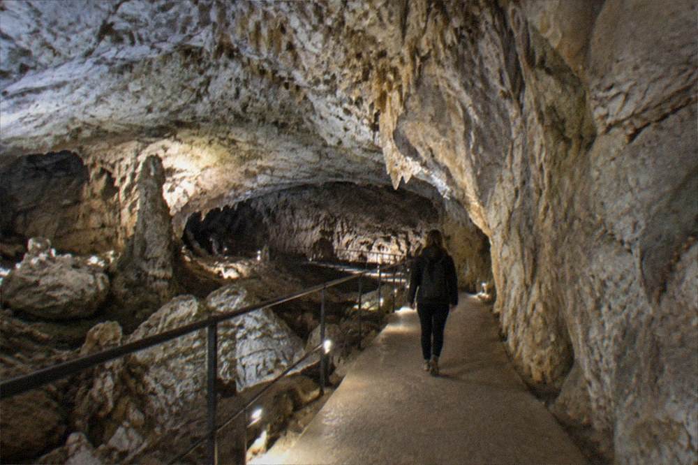 A limestone cave chamber lit for visitors on the Karst plateau
