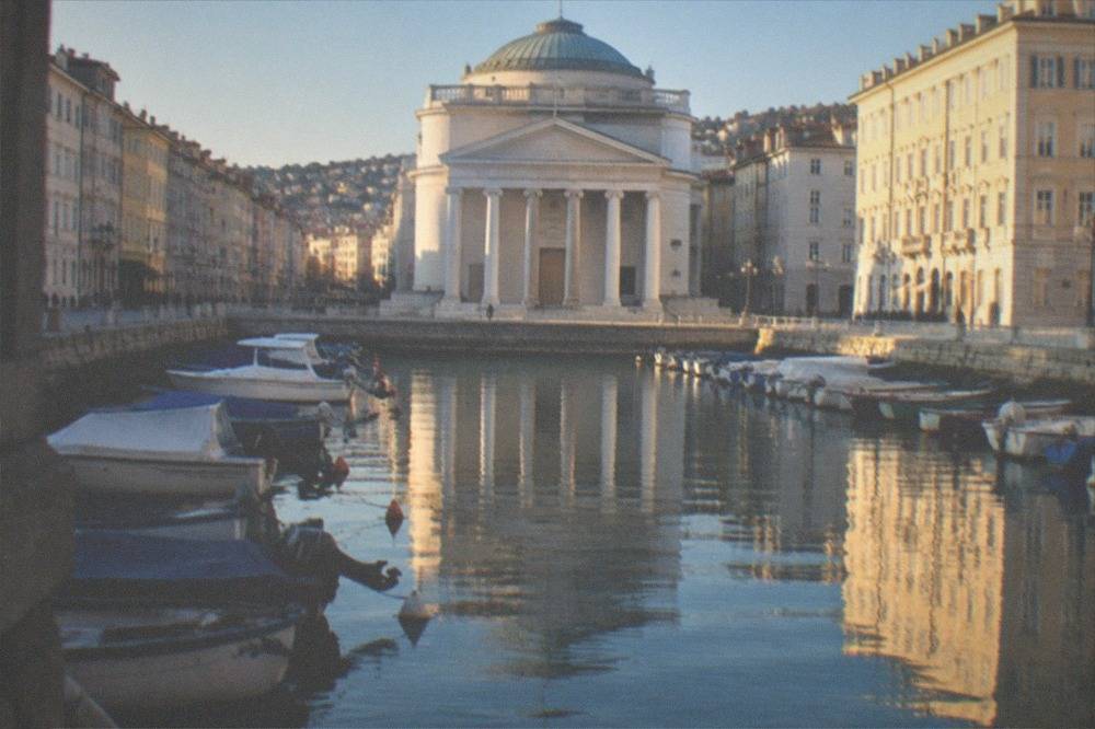 Evening light on the Grand Canal in Trieste with the Sant'Antonio church reflected in the water