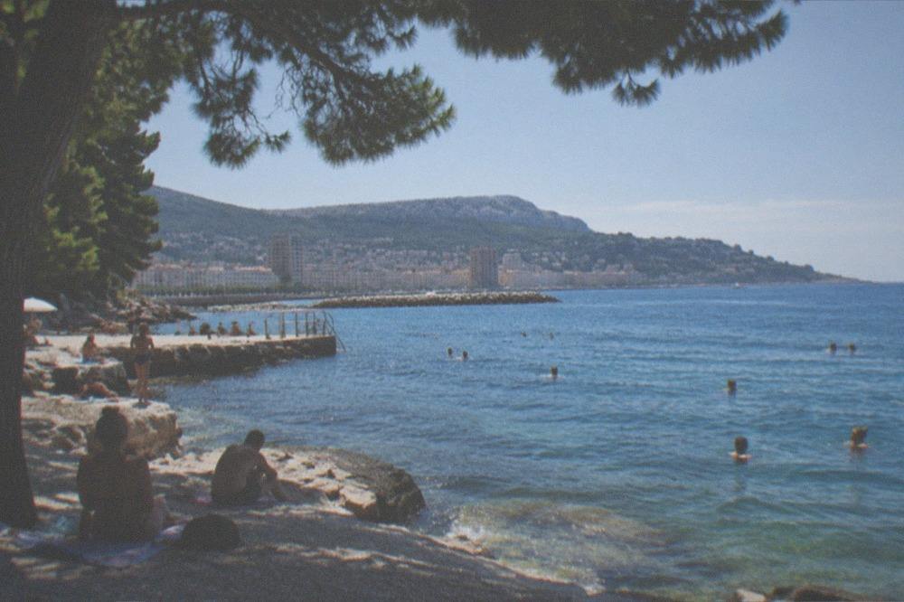 A hot summer day on a Trieste beach with swimmers in the sea