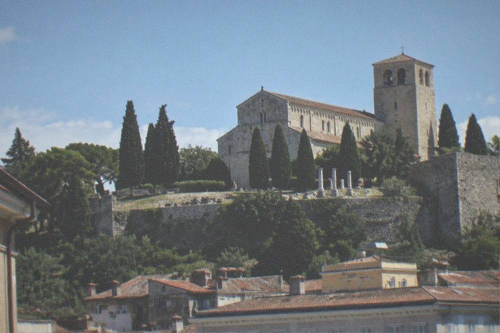 The hill of San Giusto with the cathedral and castle walls above the rooftops of Trieste