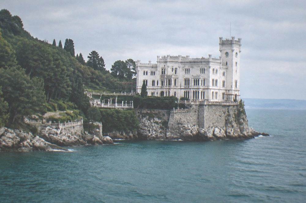 The white facade of Miramare Castle standing above the sea near Trieste