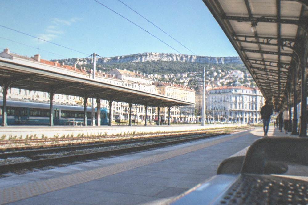 The platform and canopy of Trieste Centrale railway station with the city beyond