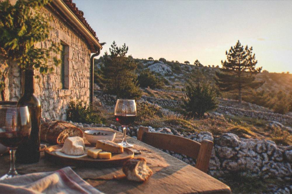 An evening table set with wine, bread and local cheeses at a Carso farmhouse