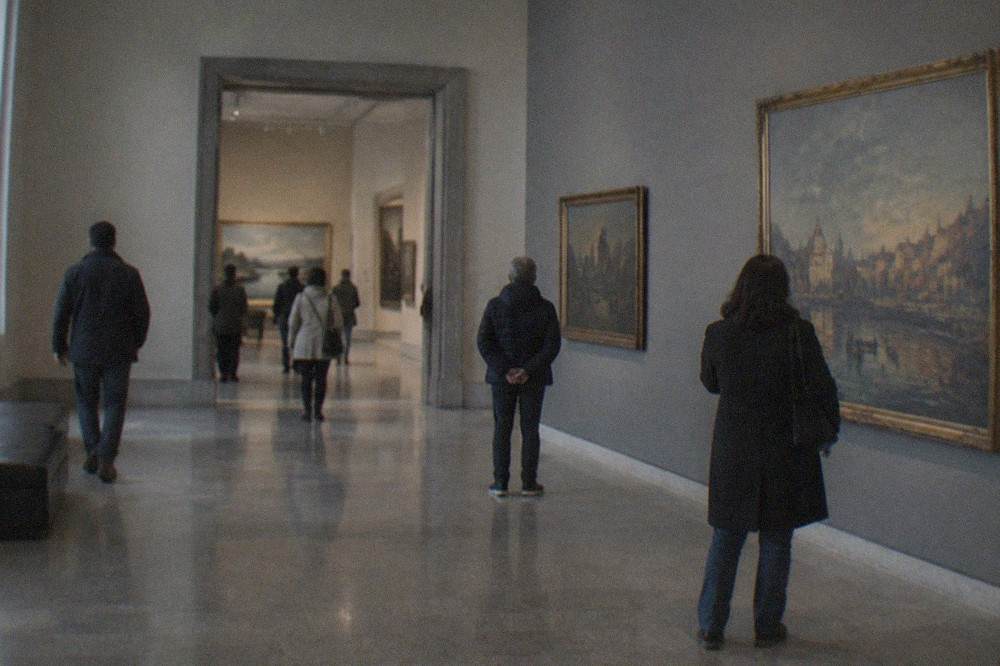 Gallery interior of the Museo Revoltella with paintings on the walls and visitors browsing