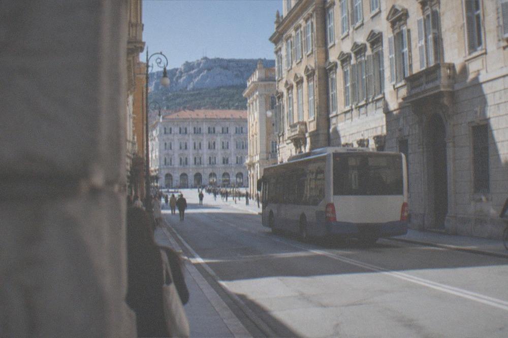 A city bus on a Trieste street beside grand period buildings
