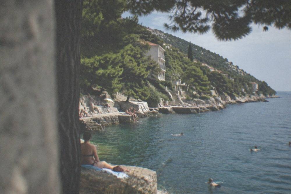 People swimming and sunbathing along the rocky seafront at Barcola north of Trieste