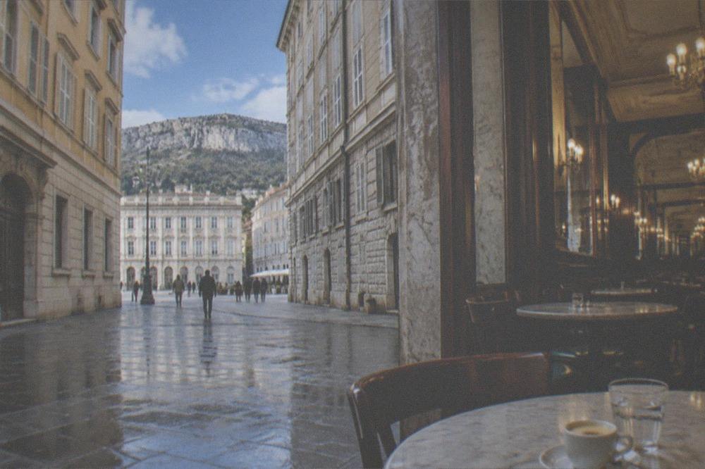 A historic Trieste coffee house interior with marble tables and chandeliers