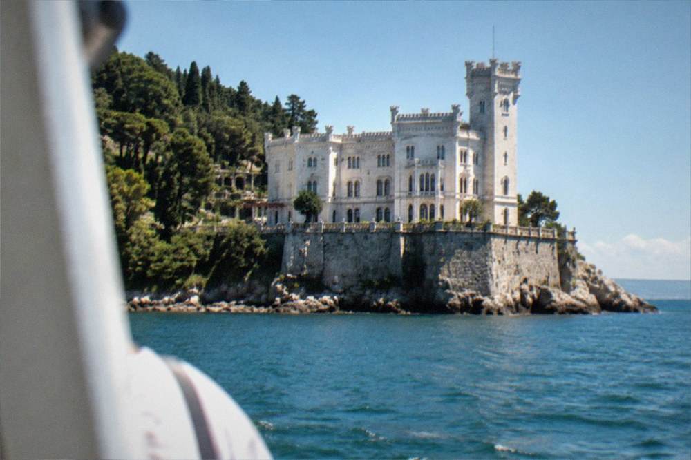 Miramare Castle above the sea with its cliffside park, seen from the water