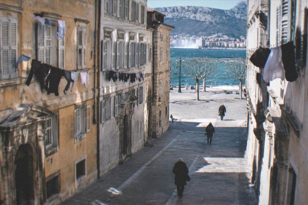 An empty winter street in the old town of Trieste with laundry lines and worn facades