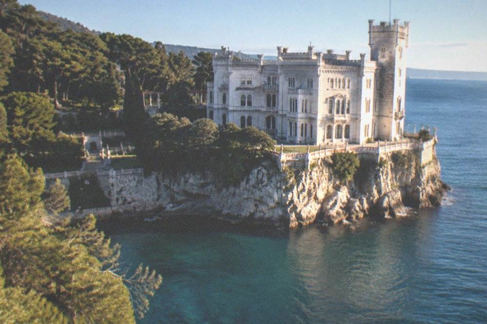The white facade and seaward terrace of Miramare Castle above the water at Grignano near Trieste